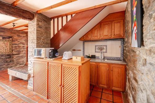 a kitchen with wooden cabinets and a microwave at Casa da Joana in Mirandela