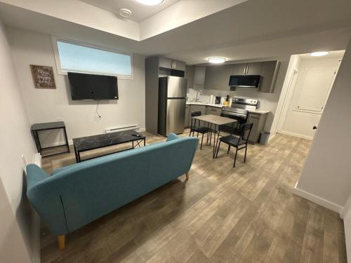 a living room with a blue couch and a kitchen at 1 bedroom- 1 bath private suit in Regina