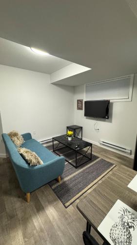 a living room with a blue couch and a tv at 1 bedroom- 1 bath private suit in Regina