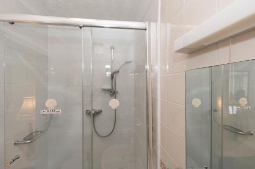a shower with a glass door in a bathroom at Shoreline Accommodation in Bournemouth