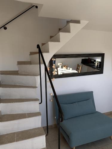 un escalier avec un miroir et une chaise bleue dans l'établissement Charmante maisonnette proche du centre du village, à La Garde-Freinet