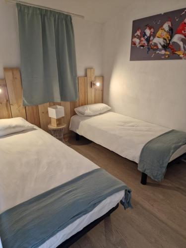 une chambre avec deux lits et une fenêtre dans l'établissement la belle cascade 2, à Dolus-d'Oléron