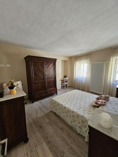a bedroom with a large bed and a wooden cabinet at Il nido dei Priori in Volterra