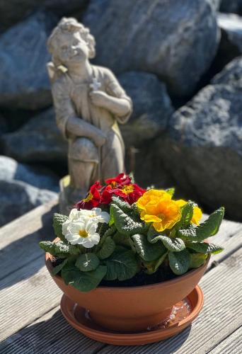 a statue of a boy sitting next to a pot of flowers at Apartmány Křivoklát in Křivoklát