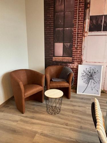 a living room with two chairs and a table at Ferienwohnung- Zur alten Waage in Schöbendorf