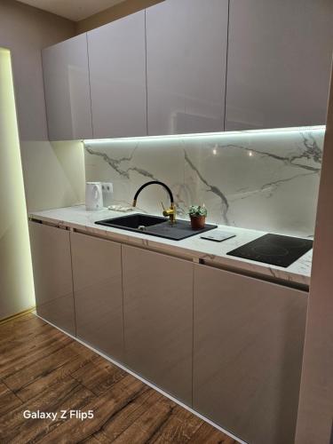 a kitchen with white cabinets and a sink at Bingo city centar in Sarajevo