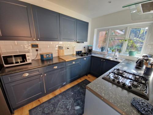 a kitchen with blue cabinets and a counter top at The Hideaway - Central Wareham, Roof terrace, Garden & Parking in Wareham