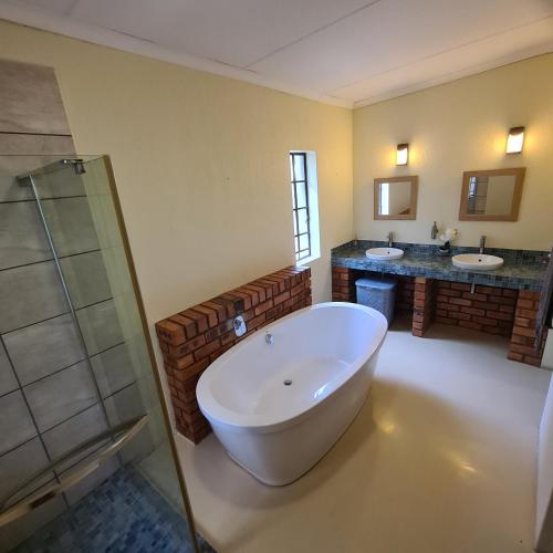 a large bathroom with two sinks and a large tub at Six Senses in Marloth Park