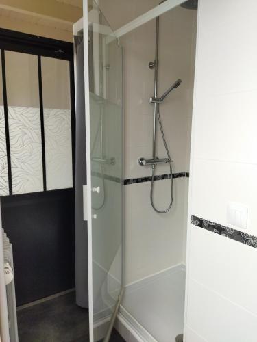une douche avec une porte vitrée dans une salle de bain dans l'établissement Maison de vacances, au Guilvinec