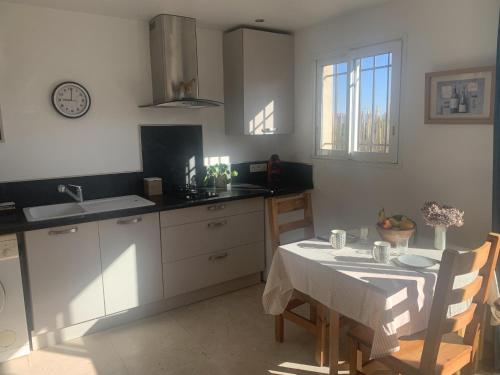 une cuisine avec une table et un chiffon de table blanc dans l'établissement Charmante maisonnette proche du centre du village, à La Garde-Freinet