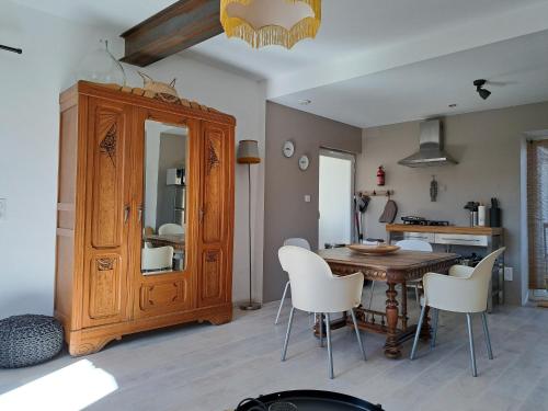 une salle à manger avec une table et des chaises blanches dans l'établissement Gîtes NouLou, appartementen in Saint-Denis, à Saint-Denis