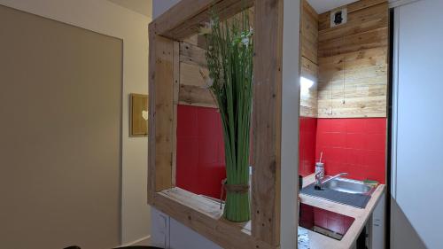La salle de bains est pourvue d'un lavabo et d'un vase avec une plante. dans l'établissement Studio spacieux - Labronie, à Sarlat-la-Canéda