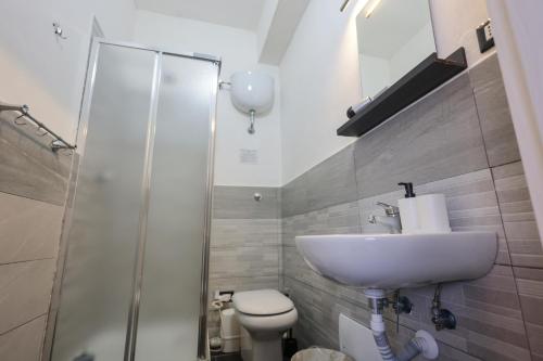 a bathroom with a sink and a toilet and a shower at A cartulina e Napulè Attico con Vista Porto Ascensore Colazione Inclusa Struttura nel cuore autentico di Napoli a 5 minuti dalla Stazione Centrale e dal Centro Storico AC in Naples