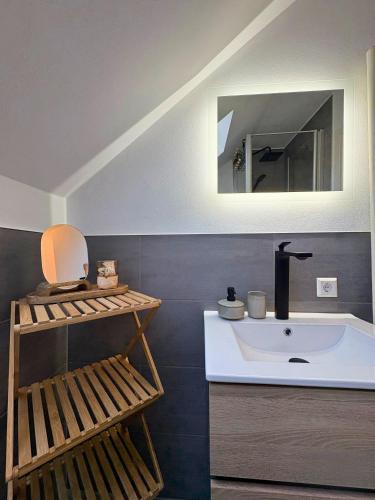 a bathroom with a white sink and a mirror at Apartment Ikigai in Cochem