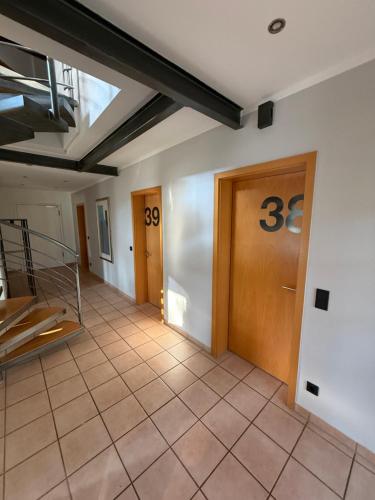 a hallway with two doors and a tile floor at Ho(s)tel Ahrbergen in Giesen