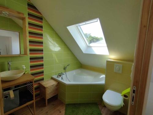 une salle de bain avec une baignoire, un lavabo et une fenêtre dans l'établissement La maison blanche et rouge, à Saint-Hélen