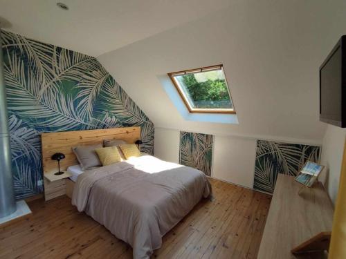 une chambre avec un grand lit et une fenêtre dans l'établissement La maison blanche et rouge, à Saint-Hélen