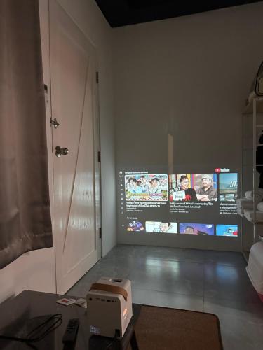 een woonkamer met een tv en een projector bij Regalohome Br in Bangkok