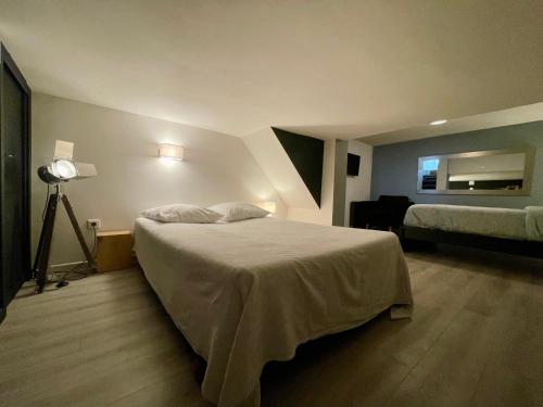 a hotel room with a bed and a lamp at Esprit loft in Talence