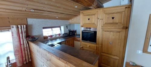 une cuisine avec des armoires en bois et un comptoir dans l'établissement Chalet La Clavarine, à Bonneval-sur-Arc