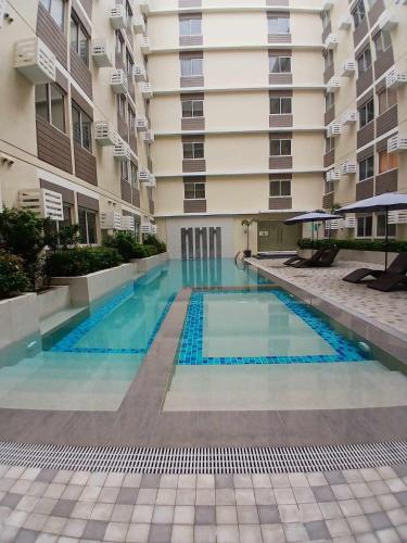a swimming pool in front of a building at Fullerton suites C homestay in Silang