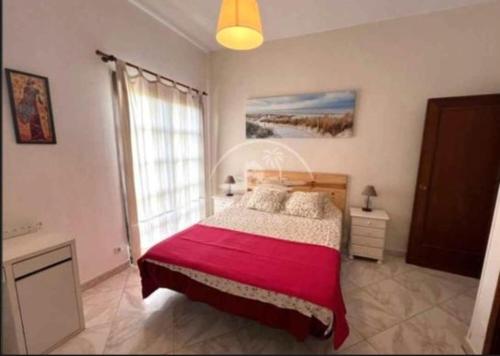 a bedroom with a large bed with a red blanket at Alhamar Cabopino Living Apartment in Málaga