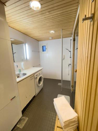 a bathroom with a sink and a washing machine at Kylpyla Spa Villa Saimaan Harmonia in Imatra