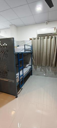 a room with a table and a curtain at V R S Luxury AC Male Dormitory in Mysore
