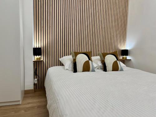 une chambre avec un grand lit avec des draps et des oreillers blancs dans l'établissement City Center, Calm & Fresh, à Aix-en-Provence