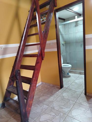 a wooden ladder in a bathroom with a toilet at Cabaña J y M in Samaipata