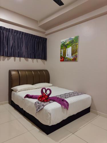 a bedroom with a bed with a bow on it at ATS Cameron Hotel & Apartments in Cameron Highlands