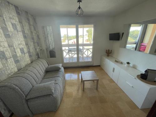 un salon avec un canapé et une table dans l'établissement Studio Sète vue sur l’étang de Thau, à Sète