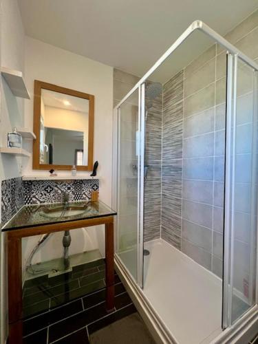 une salle de bain avec une douche en verre et un lavabo dans l'établissement L'escapade ardéchoise, à Aubenas