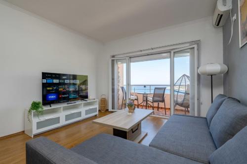 Una sala de estar con un sofá, un televisor y una mesa. en Azzurro Apartment in Utjeha, en Utjeha