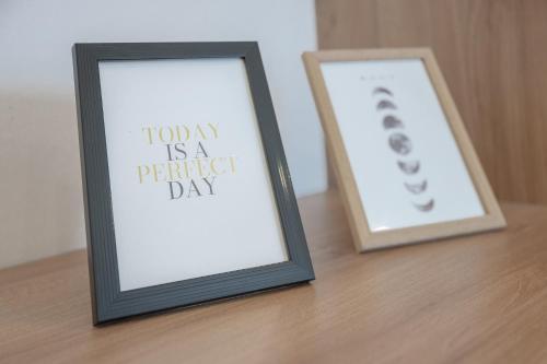 two framed signs sitting on a wooden table at Amaria Downtown Aparthotel Villach in Villach