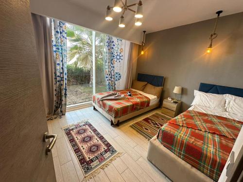 Un dormitorio con dos camas y una puerta con ventana. en العين السخنة المونت جلالة-il monte galala, en Ain Sokhna