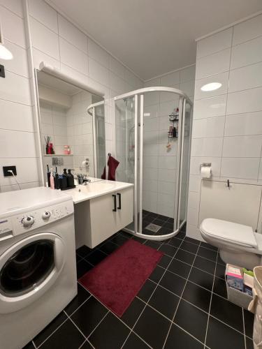 a bathroom with a washing machine and a sink at 3-room downtown apartment in Trondheim