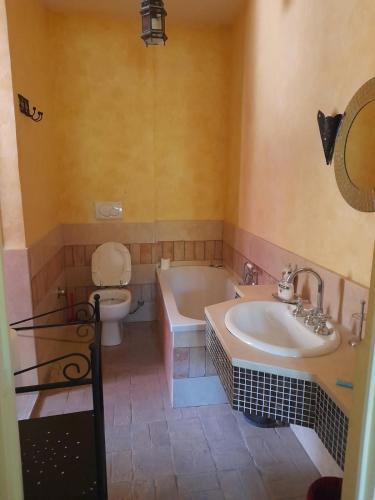 a bathroom with a tub and a toilet and a sink at Villa Eliana Fregene in Fregene