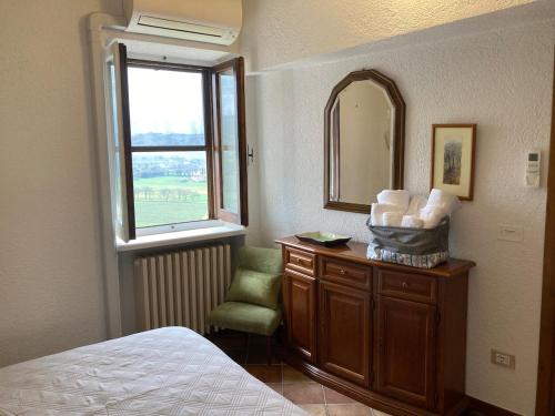 une chambre avec un lit, un miroir et une chaise dans l'établissement Sogni d'Oro Spello, à Spello