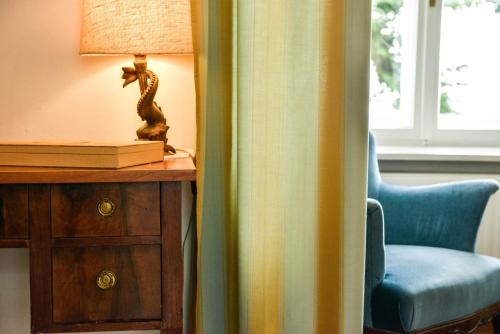 a room with a chair and a table with a lamp at Schloss Kapfenstein in Kapfenstein