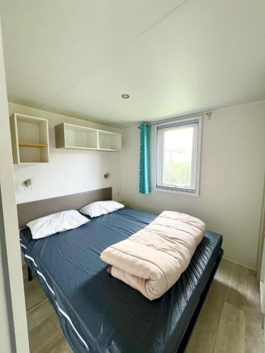 une chambre avec un lit dans une pièce avec une fenêtre dans l'établissement Mobil-home Argelès-sur-Mer, à Argelès-sur-Mer