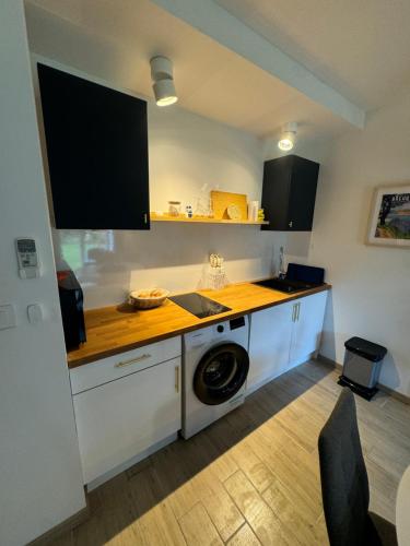 une cuisine avec une machine à laver dans une cuisine dans l'établissement gite penelope, à Mont-Dol