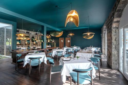 a restaurant with white tables and blue walls at Casa Senhora da Rosa in Ponta Delgada