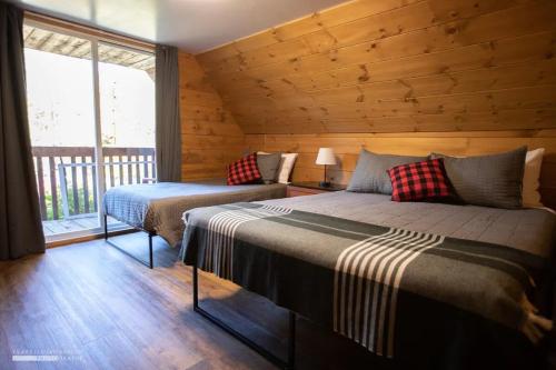 a bedroom with two beds in a log cabin at Chalet Le Merlot in Mandeville