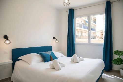 - une chambre dotée d'un grand lit blanc avec deux animaux rembourrés dans l'établissement Appartement tout confort au Cœur d'Antibes, à Antibes