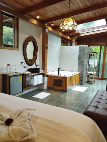 a bedroom with a tub and a table and a couch at Saguamby Mindo Lodge in Mindo