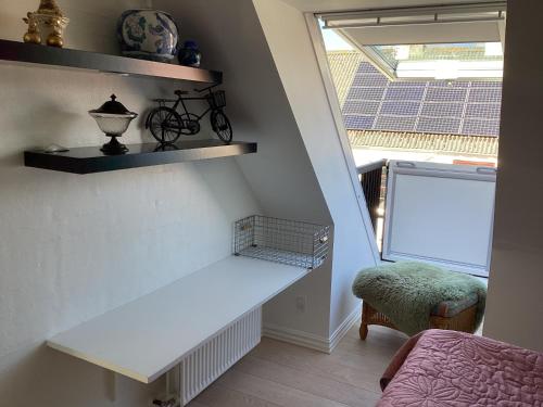 a white bench in a room with a window at Dejlig feriehus i den gamle bydel in Løgstør