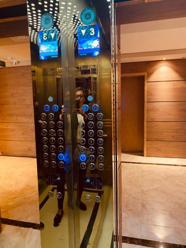 a man in a glass case with a giant remote control at Dreamland Oasis Hotel Chakvi 14310 in Chakvi