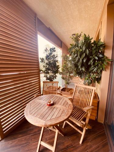 a table and two chairs in a room with plants at Dreamland Oasis Hotel Chakvi 14310 in Chakvi