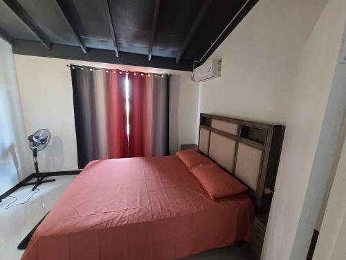 una camera da letto con un letto rosso e una tenda rossa di Cozy Comfort a Kingston